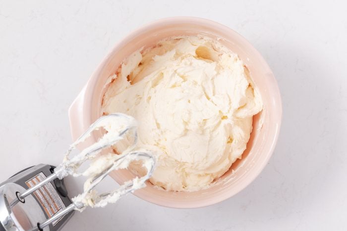 Confectioners sugar and butter beaten with salt and vanilla extract in mixing bowl.