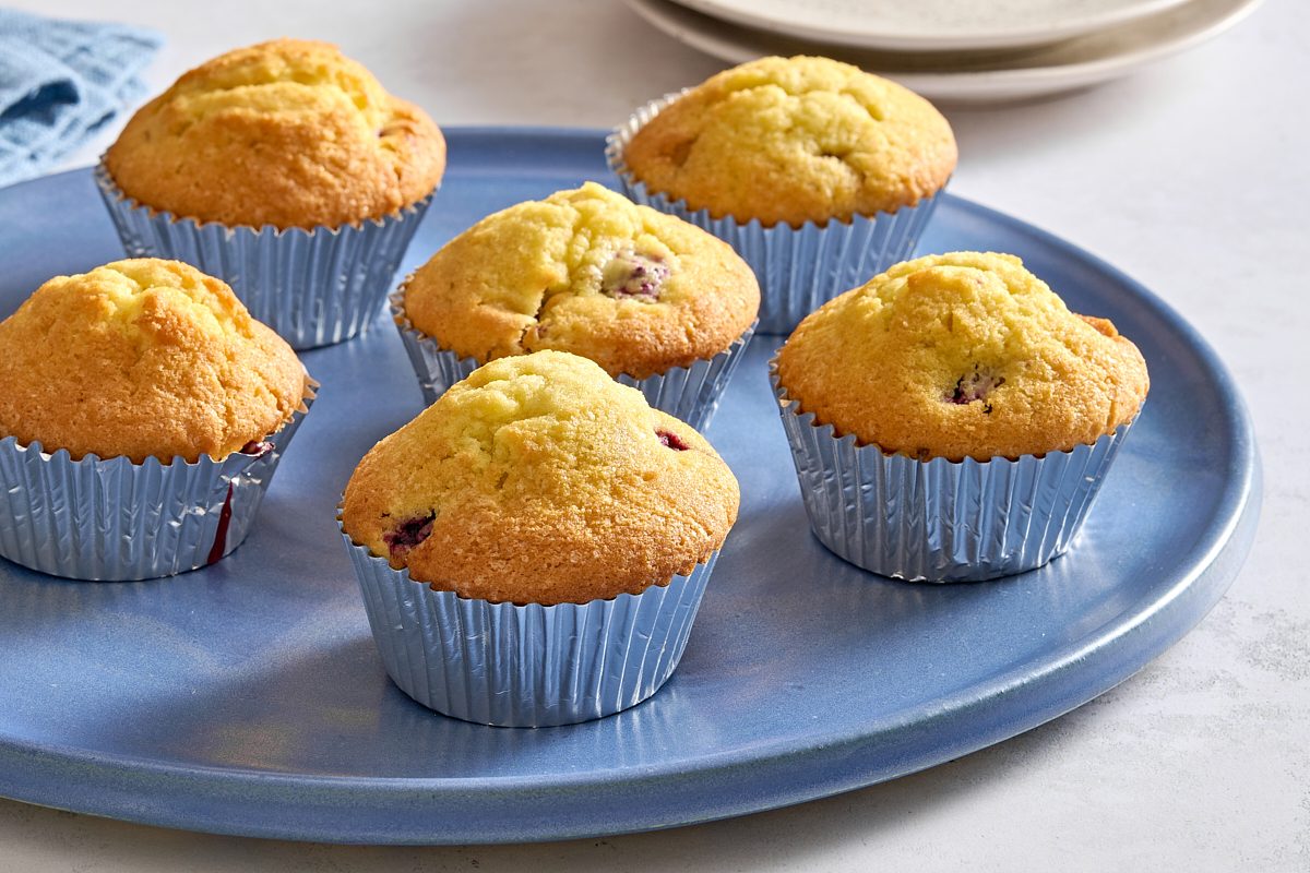 Straight-on shot of several blackberry muffins on a serving plate