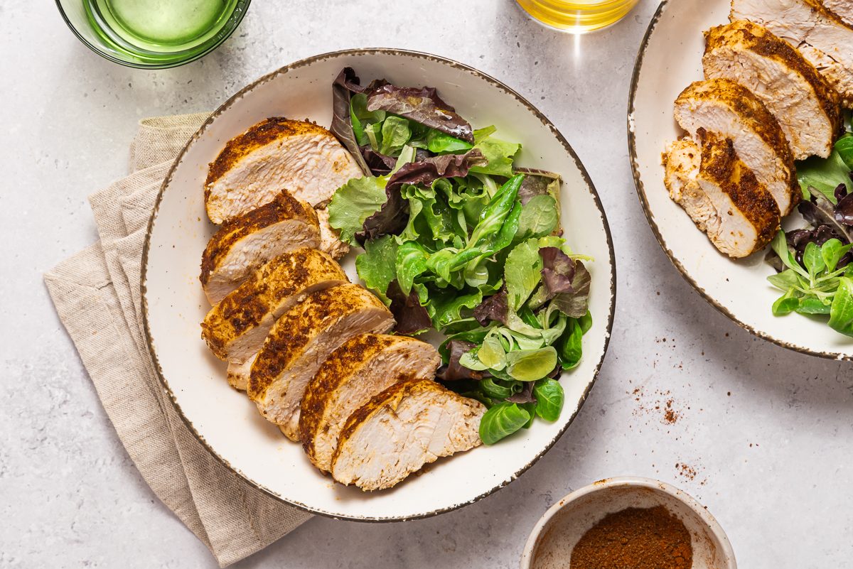 Plates With Sliced Blackened Chicken And Salad