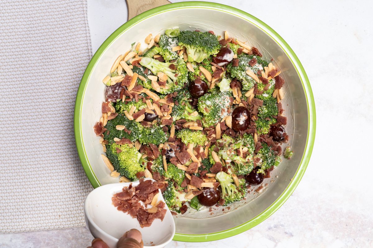 Adding bacon bites to the salad