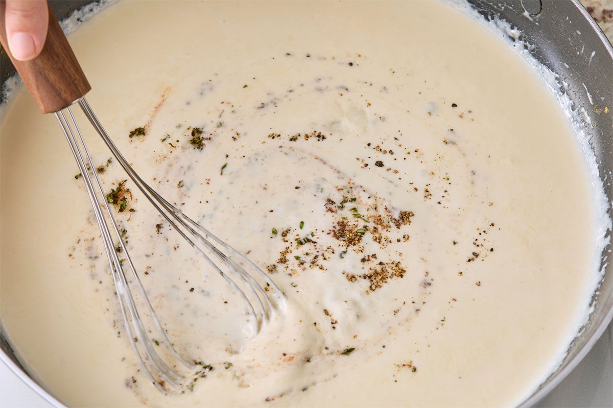 Close shot of stir in thyme; nutmeg; remaining 1/2 teaspoon salt and remaining 1/4 teaspoon pepper; remove from heat; whisk marble surface;