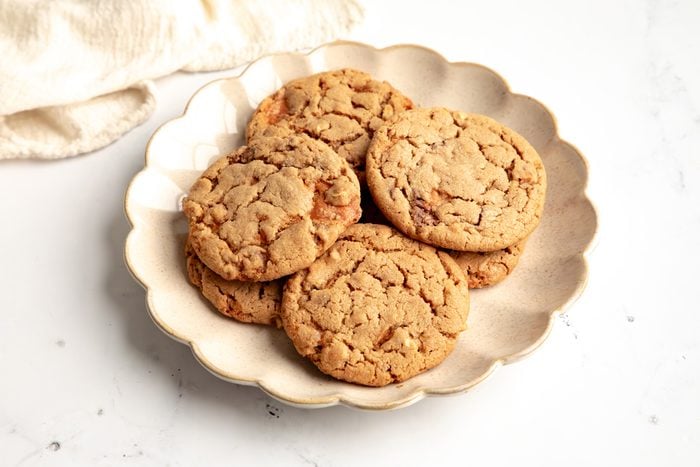 Close up beauty shot for Taste of Home Butterfinger Cookies being served on a scalloped plate.