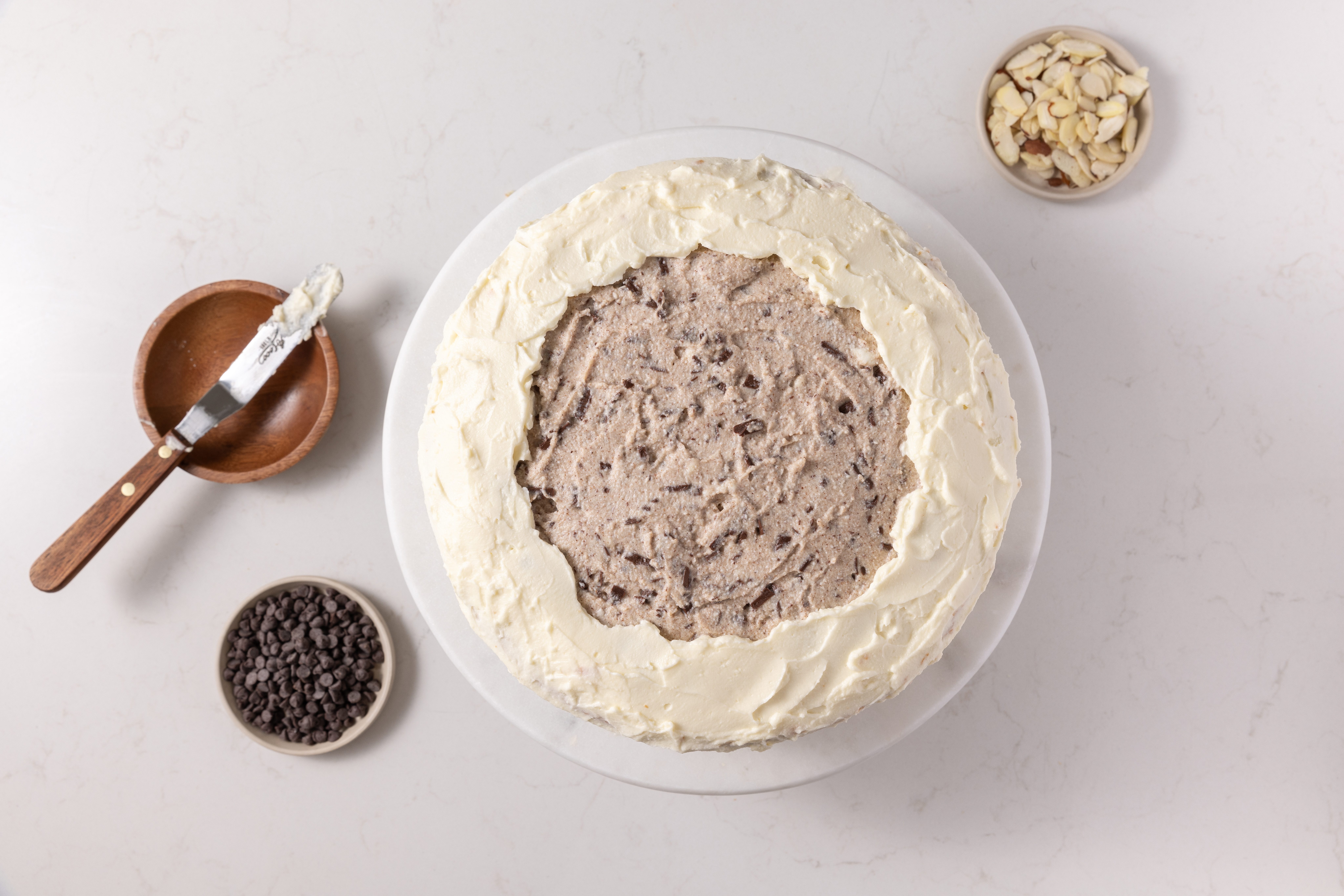 Cake layers being assembled and finished with frosting.
