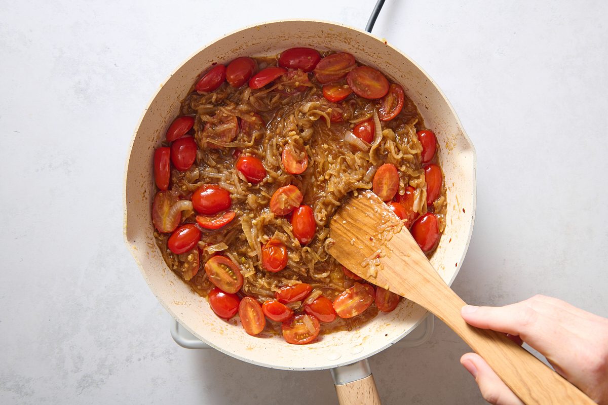 Adding the tomatoes, vinegar and oil to the pan