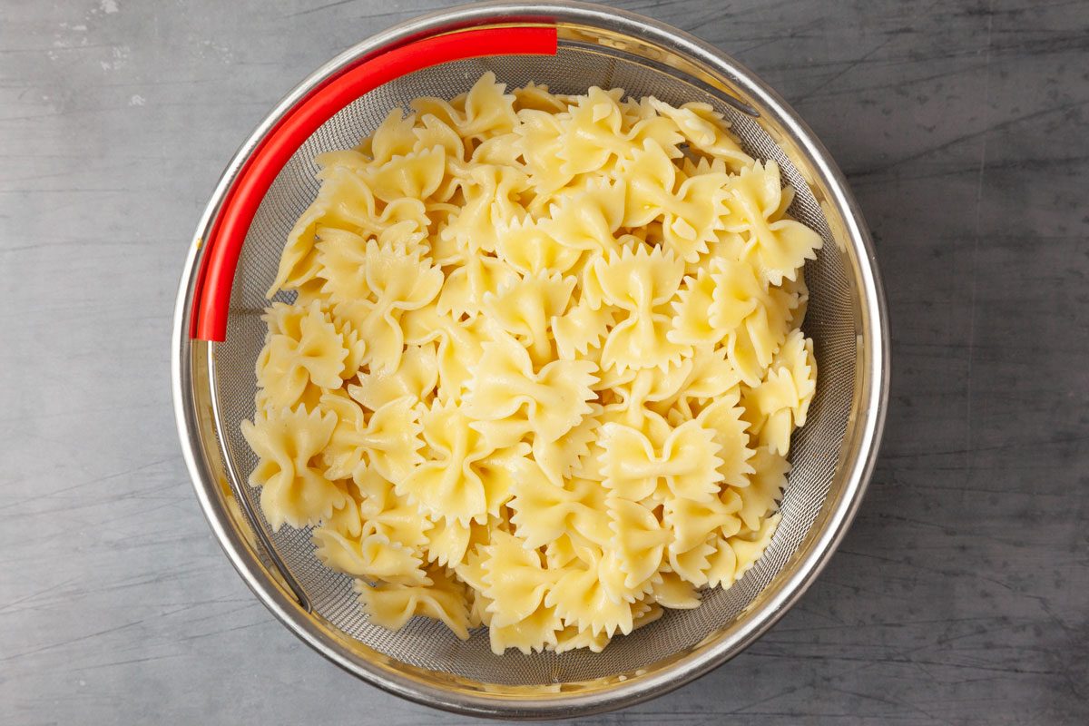 Step 1 of Taste of Home Chickpea Pasta Salad is to Cook the pasta according to the package directions. Drain it, rinse it in cold water and transfer it to a large bowl.