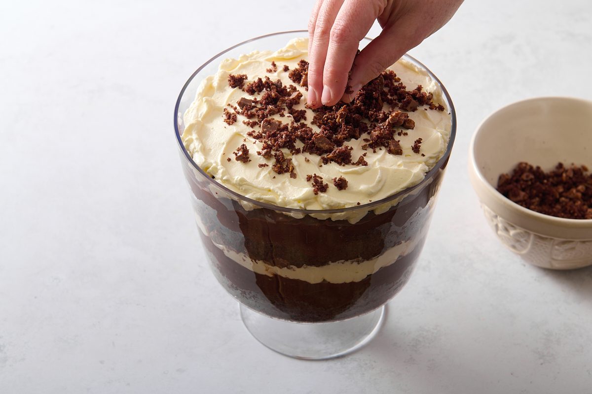 Sprinkling the topping over the trifle