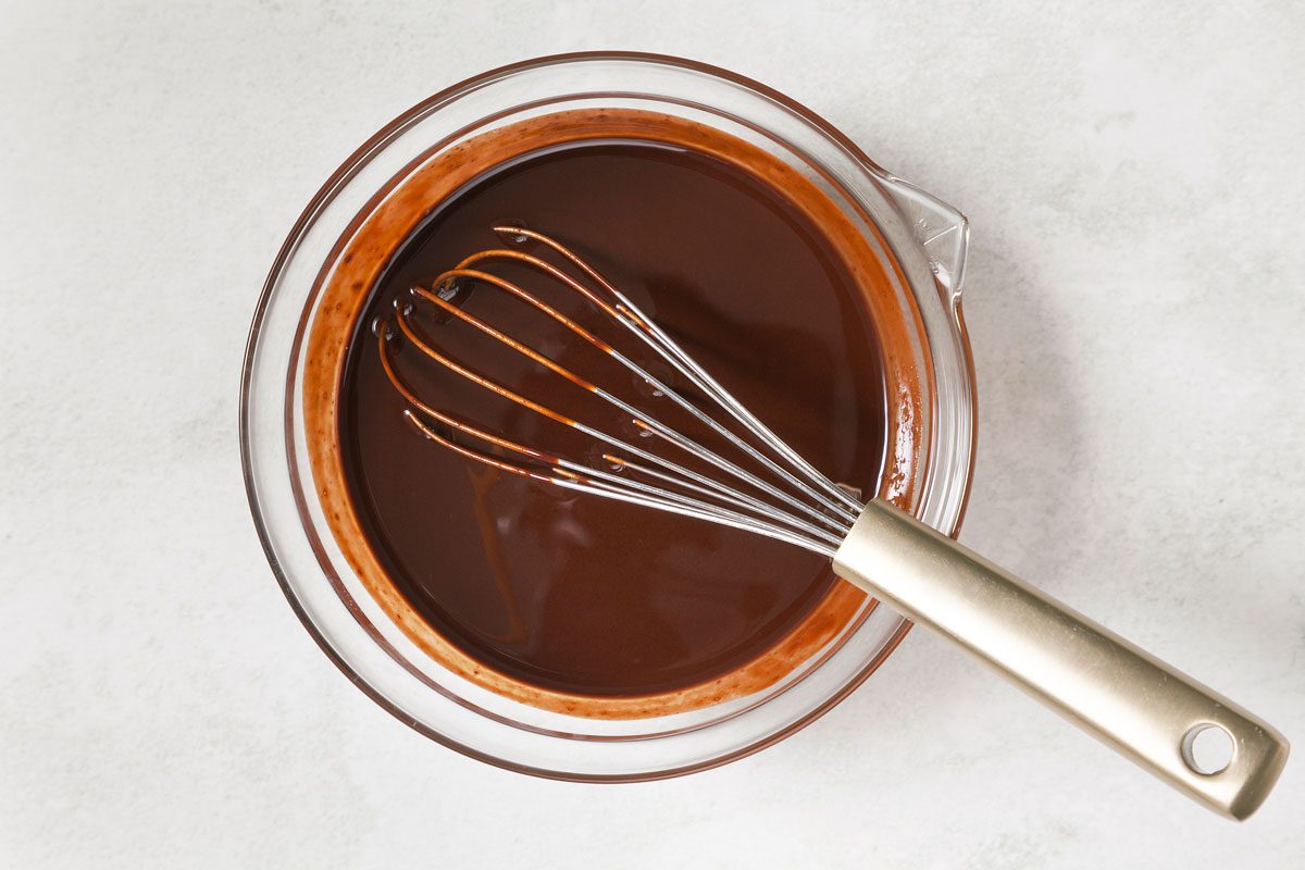 melted chocolate in a bowl with a whisk