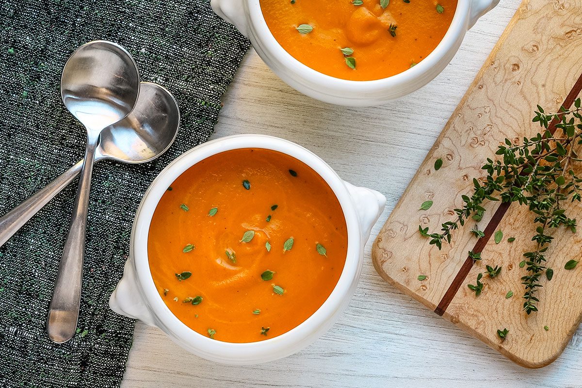 Overhead shot of bowls of homemade carrot soup.