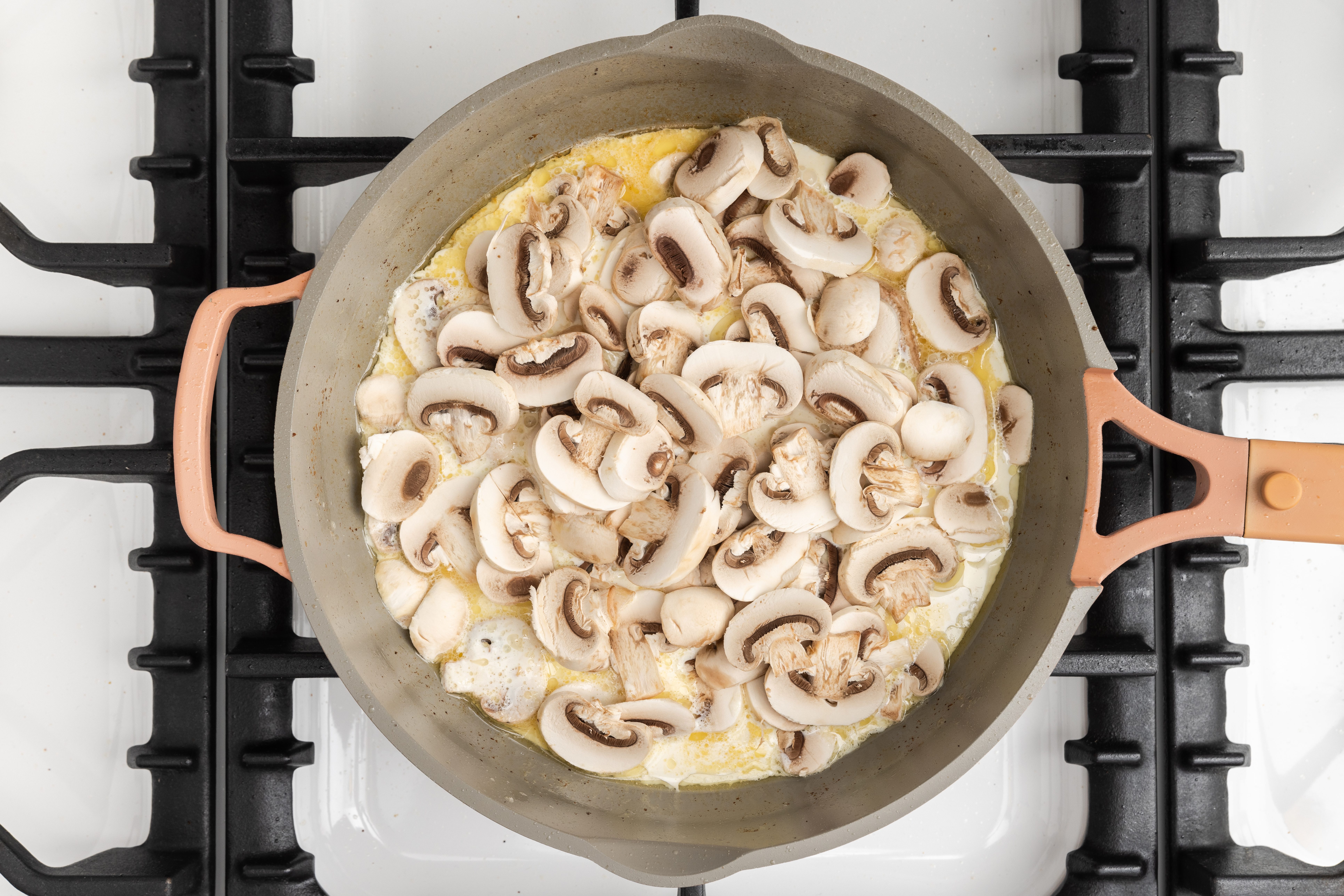 Mushrooms and cream being added to the sauce base.