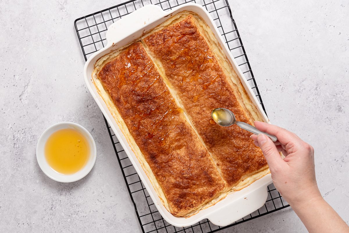 Honey Being Drizzled On Crescent Roll Cheesecake