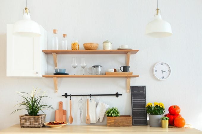 Interior of empty modern white kitchen with various objects