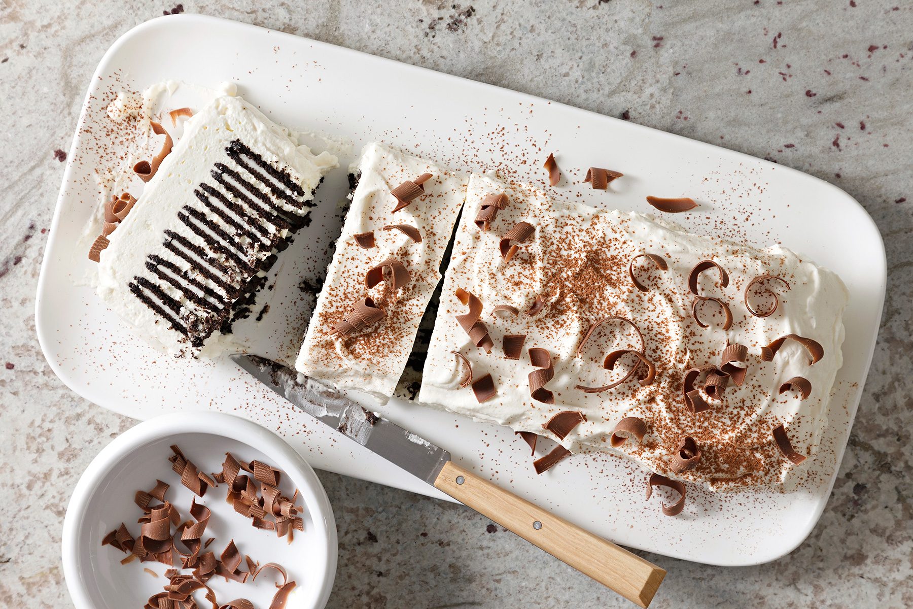 overhead shot of icebox cake topped chocolate curls and cocoa powder