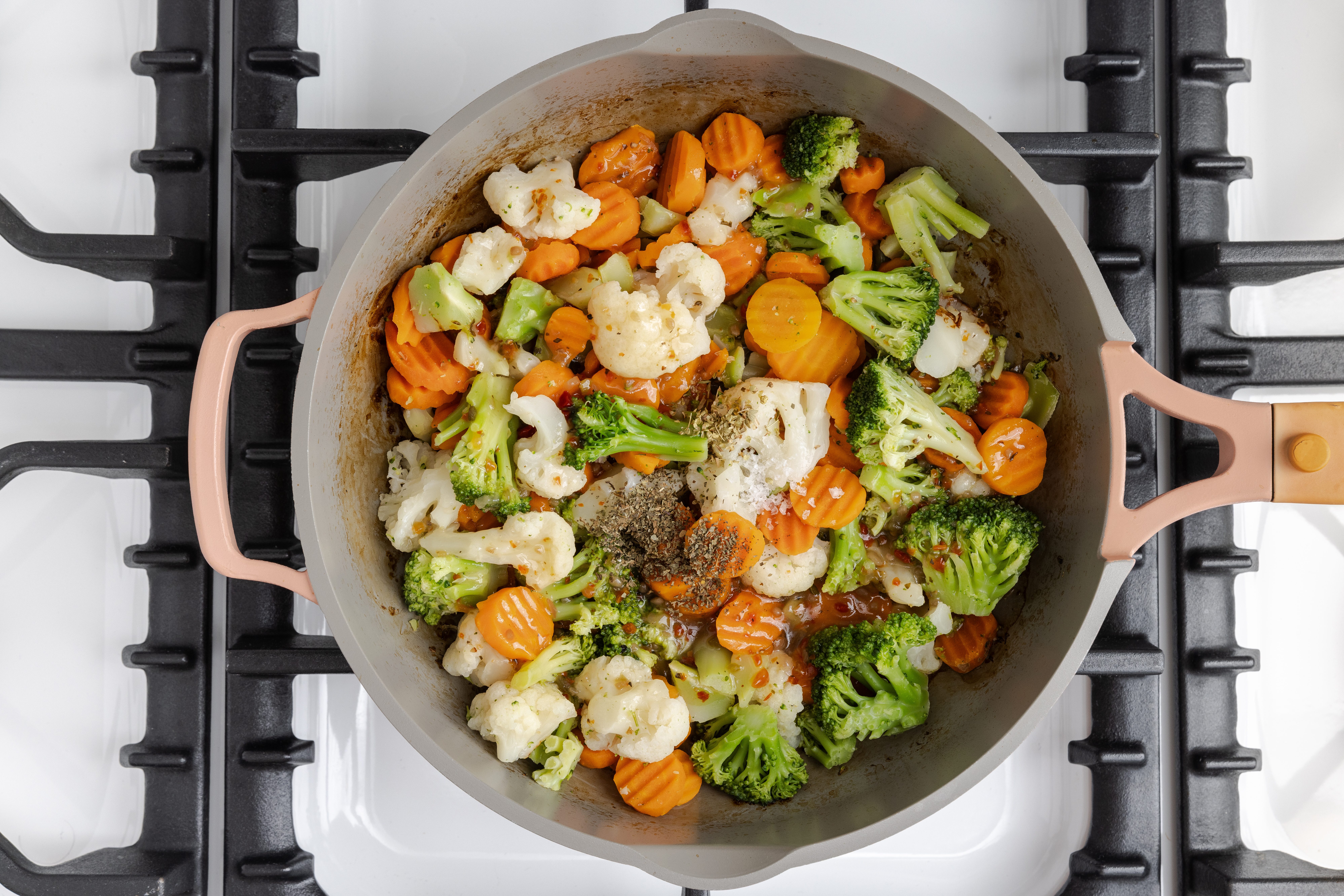Italian salad dressing, dried oregano and dried basil combined with vegetables in skillet.