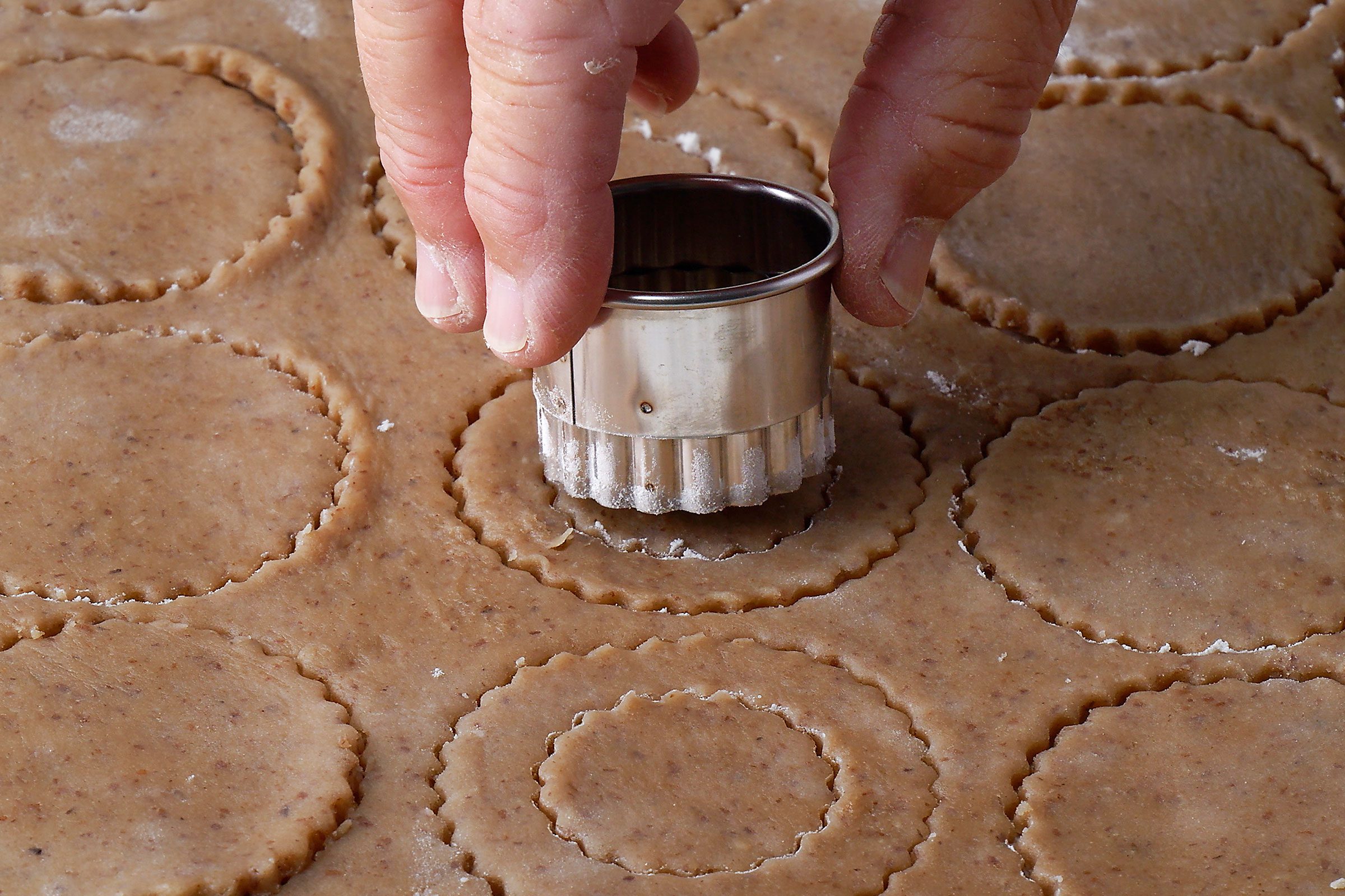 Cutting the rolled dough with centre of half the cookies