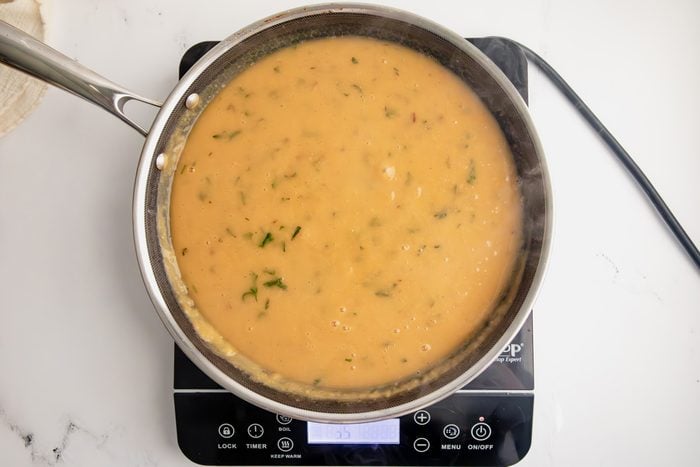 Overhead shot for Taste of Home Open Faced Turkey Sandwich, gravy cooking in a HexClad pan over an induction stovetop.