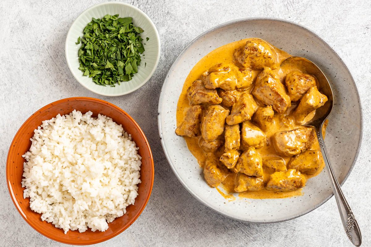 Paprika Pork in a skillet with a side of rice before serving