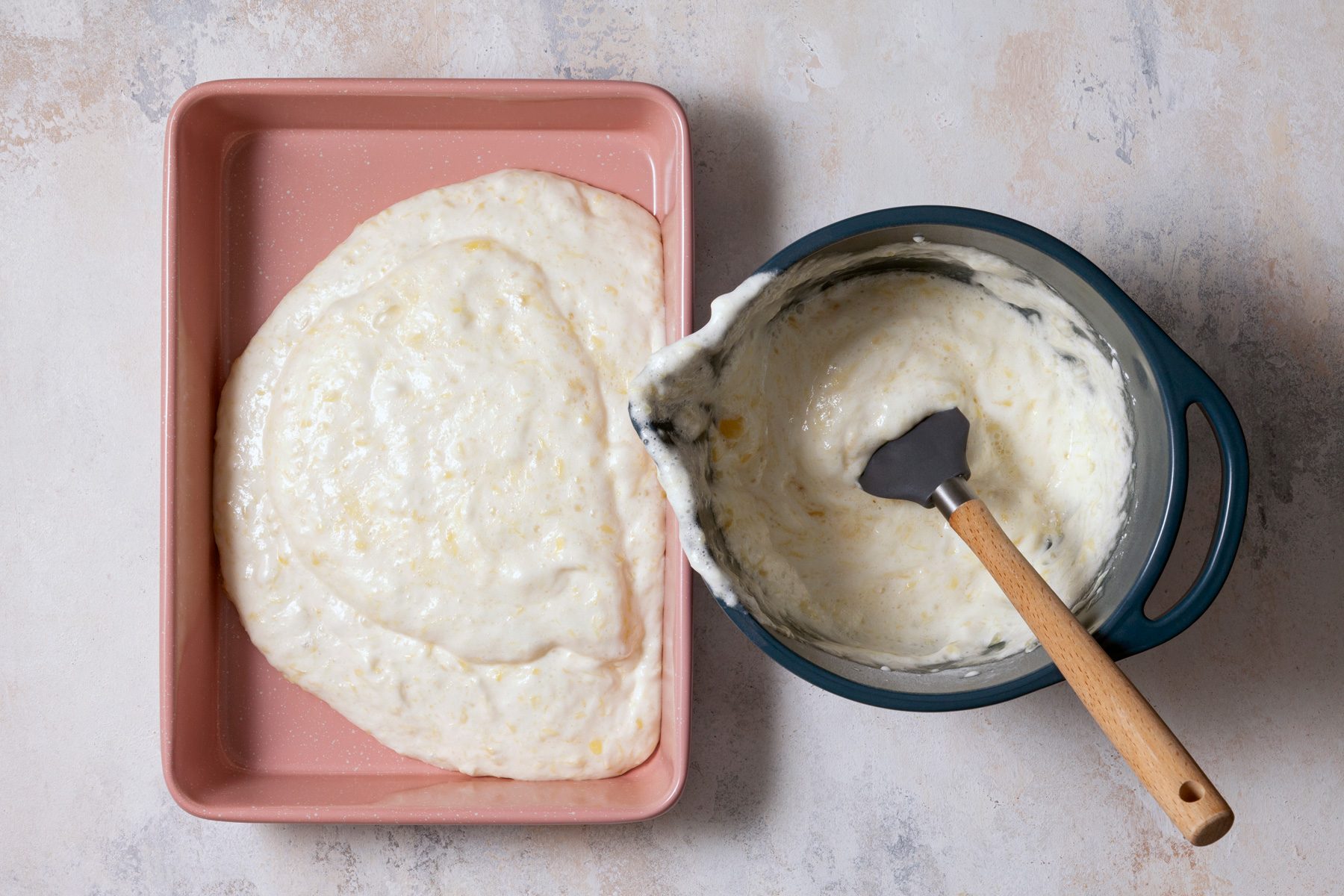 The prepared cake mix is being transferred into a baking dish, ready for baking.