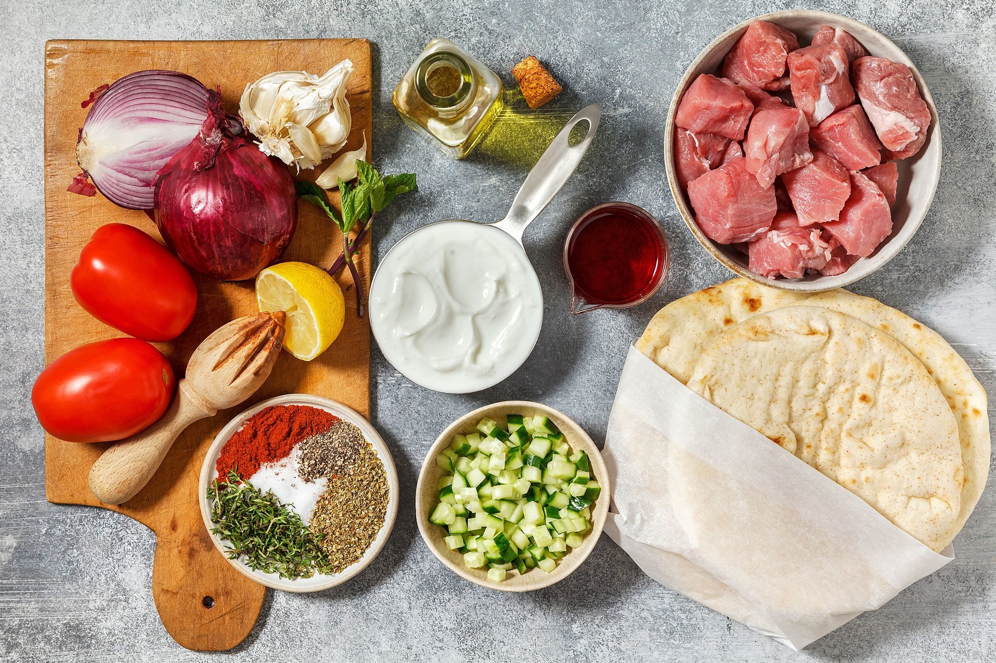 overhead shot of Pork Souvlaki ingredients placed over light gray background;