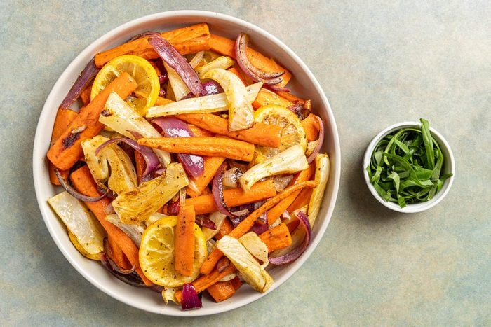 Taste of Home Roasted Fennel and Carrots photo of the roasted veggies on a serving platter with basil to garnish.