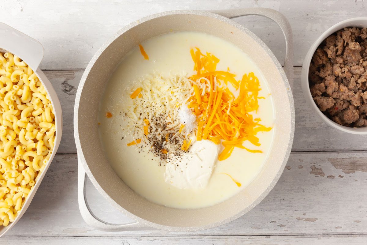 Step 3 of Taste of Home Sausage Mac and Cheese is to add the garlic and cook for one minute longer. Stir in the flour until well combined. Gradually add milk and cook until thickened, about three to four minutes, whisking occasionally. Stir in the cheddar, Monterey Jack, cream cheese, salt and pepper. Cook until the cheeses have melted. Mix in the cooked macaroni and reserved sausage.