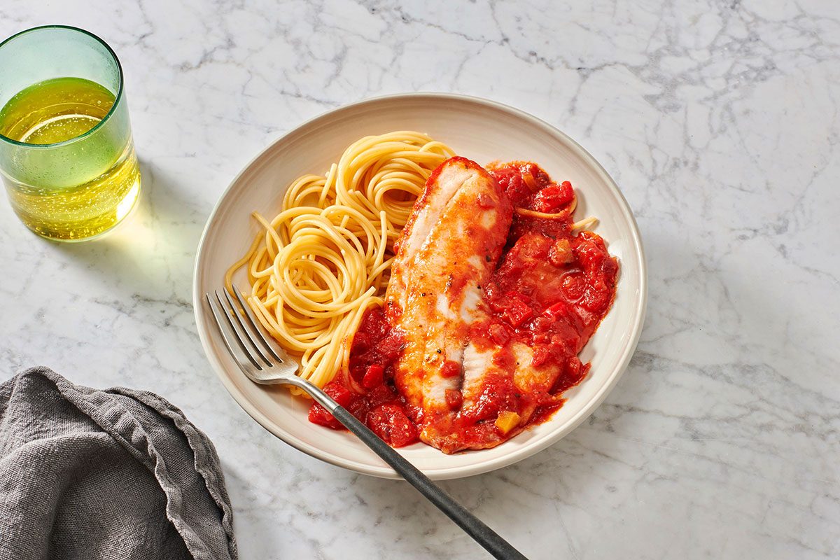 Tilapia served with pasta on a plate