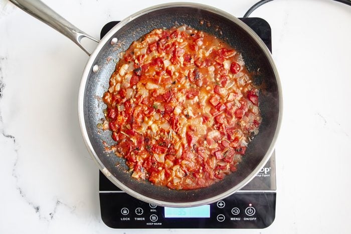 Overhead shot for Taste of Home Seafood Linguine, sauce mixture cooking in a Hexclad over an induction cooktop.