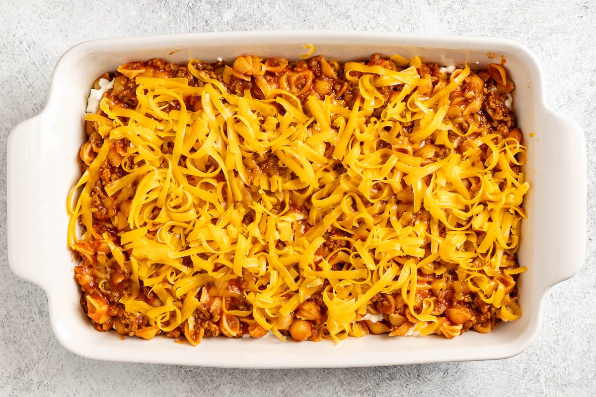 Taste of Home Sloppy Joe Pasta photo of the mixture added to a 2.5 quart baking dish and topped with cheddar cheese.