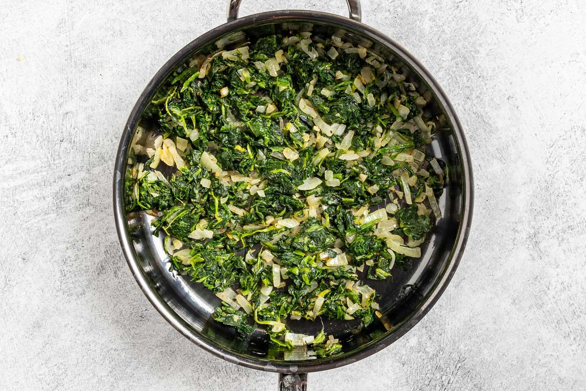Taste of Home Spinach Bread photo of cooking the onion, garlic and spinach.