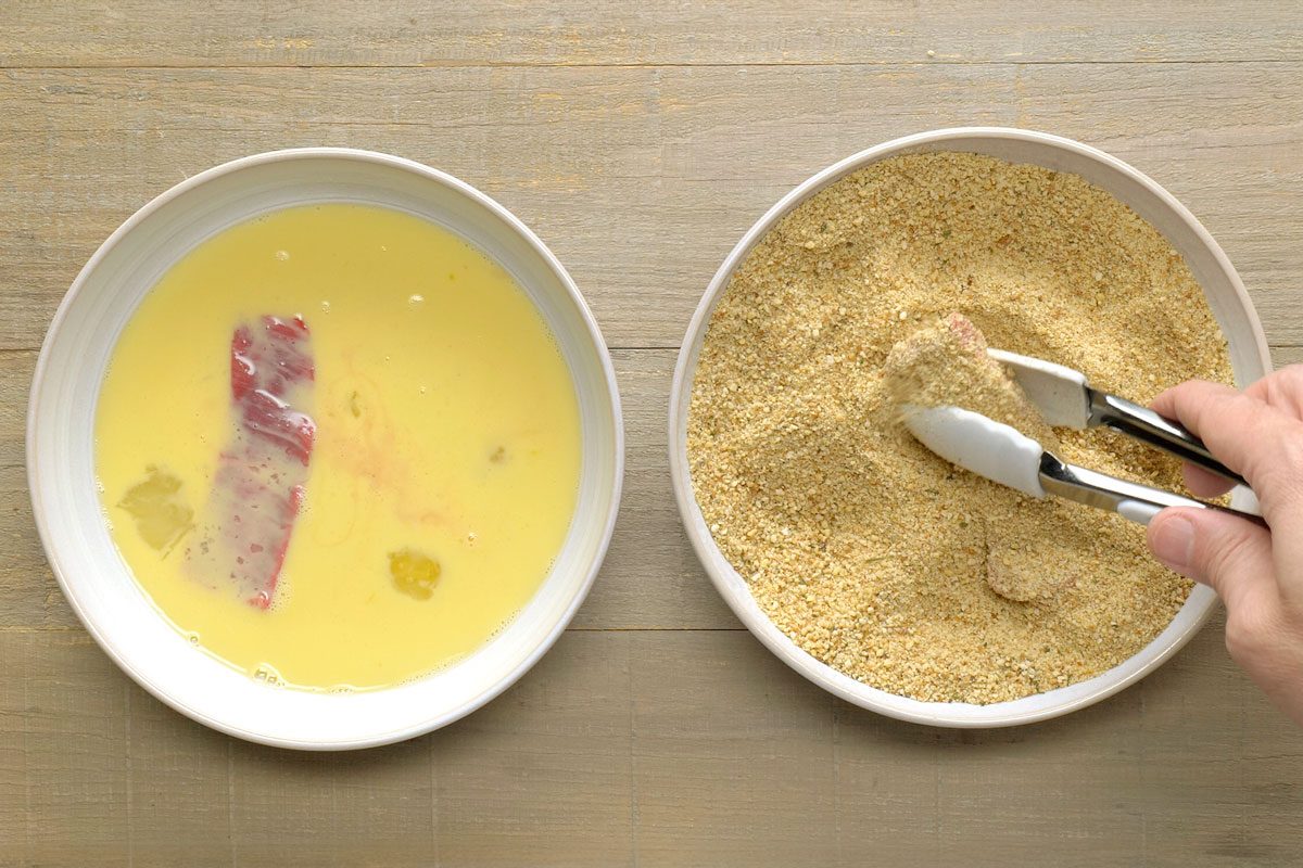 Overhead Shot Of Roll In Crumbs; With Tongs; Wooden Surface;