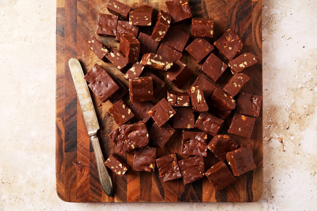 Process of making Taste of Home's Velveeta Fudge sliced on a cutting board on a brown marble surface.