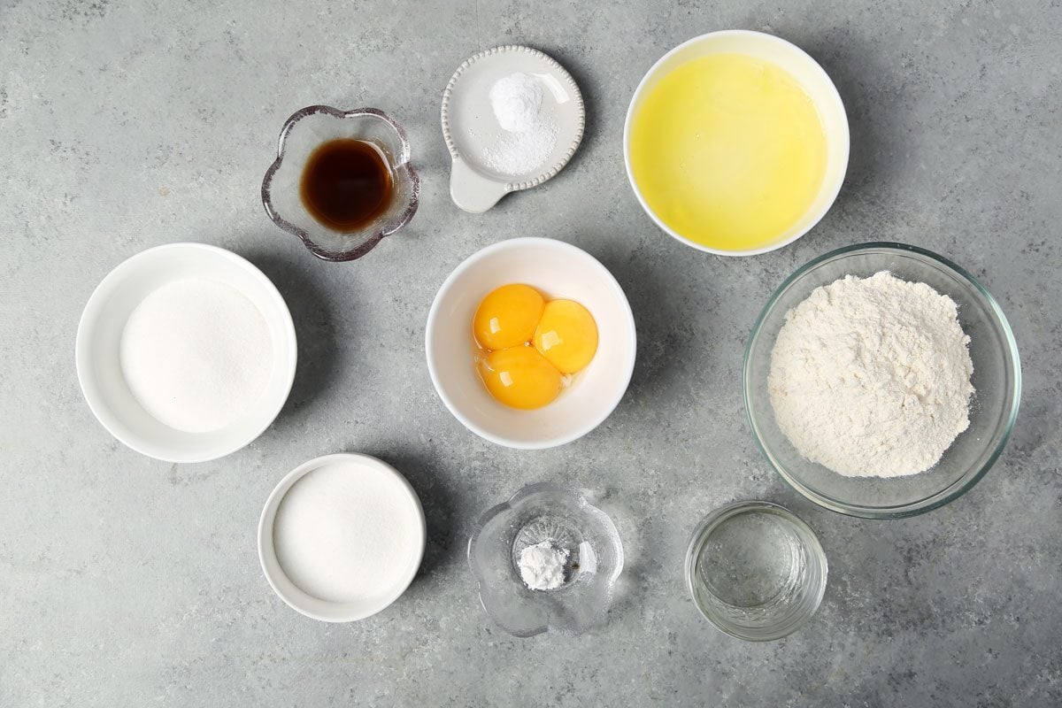 Ingredients for Taste of Home's Lady Fingers laid out in small bowls on a grey marble surface.