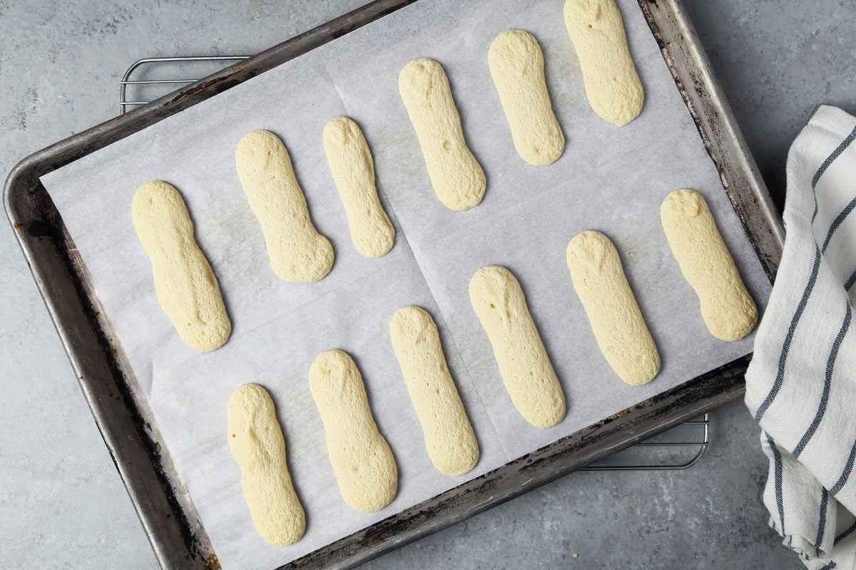 Process of making Taste of Home's Lady Fingers on a baking sheet on a wire rack.