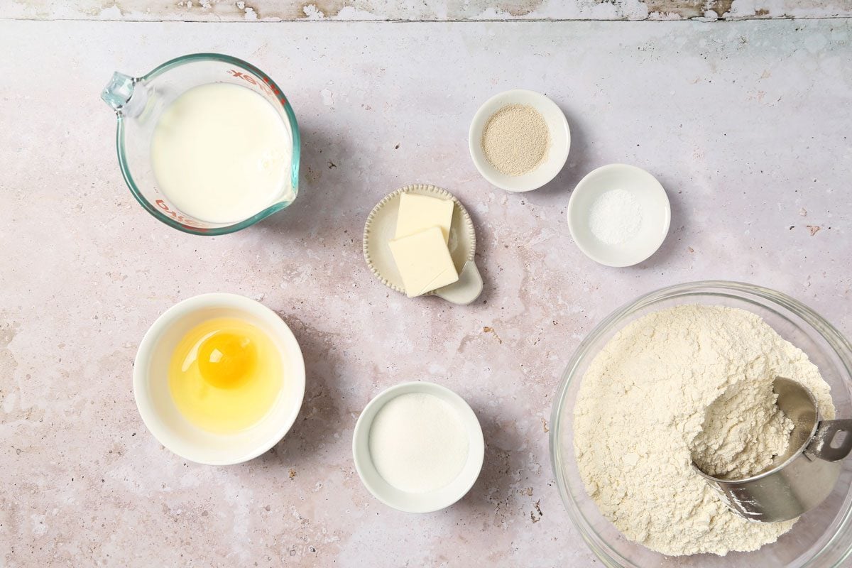 Ingredients for Taste of Home's Italian Sweet Bread laid out in small bowls on a grey and beige surface.