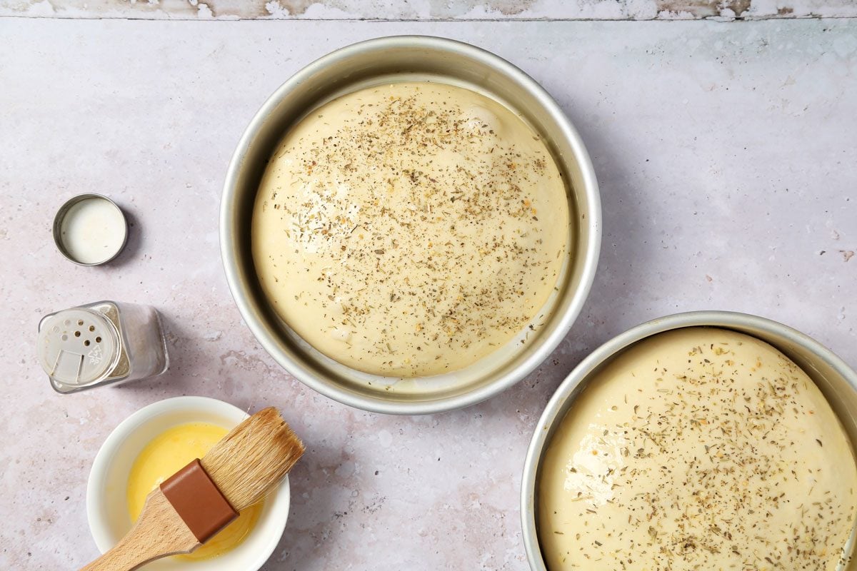 Process of making Taste of Home's Italian Sweet Bread loaves cooling on a wire rack on a grey and beige surface.