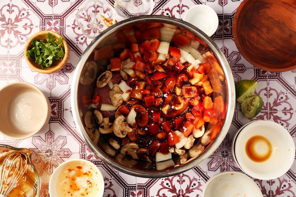 Process of making Taste of Home's Pork Bowl in a pressure cooker on a red and white tiled surface.
