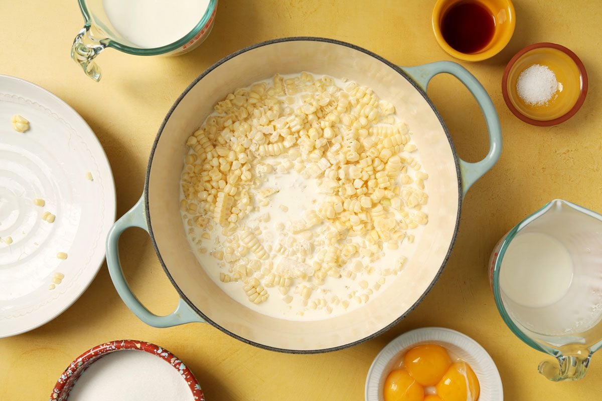 Process of making Taste of Home's Corn Ice Cream in a large pot on a yellow surface.