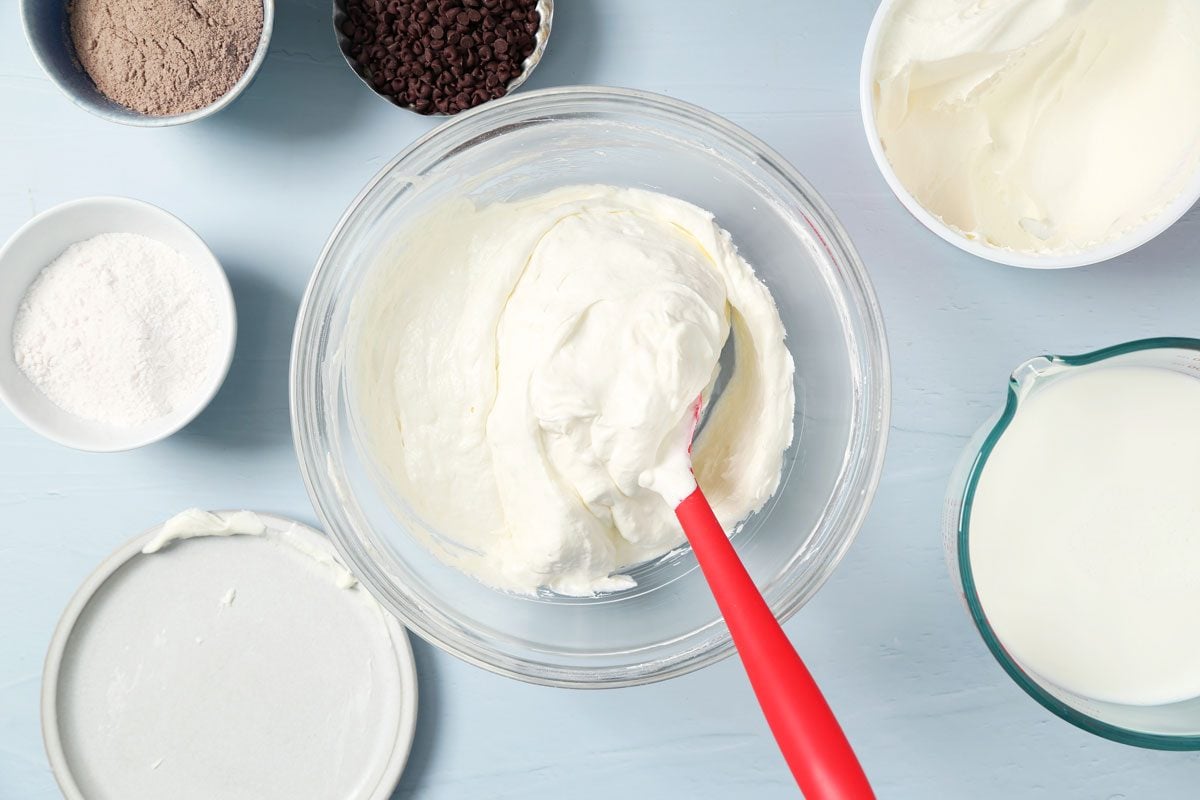 Process of making Taste of Home's Chocolate Chip Cookie Delight in a baking pan on a light blue surface.