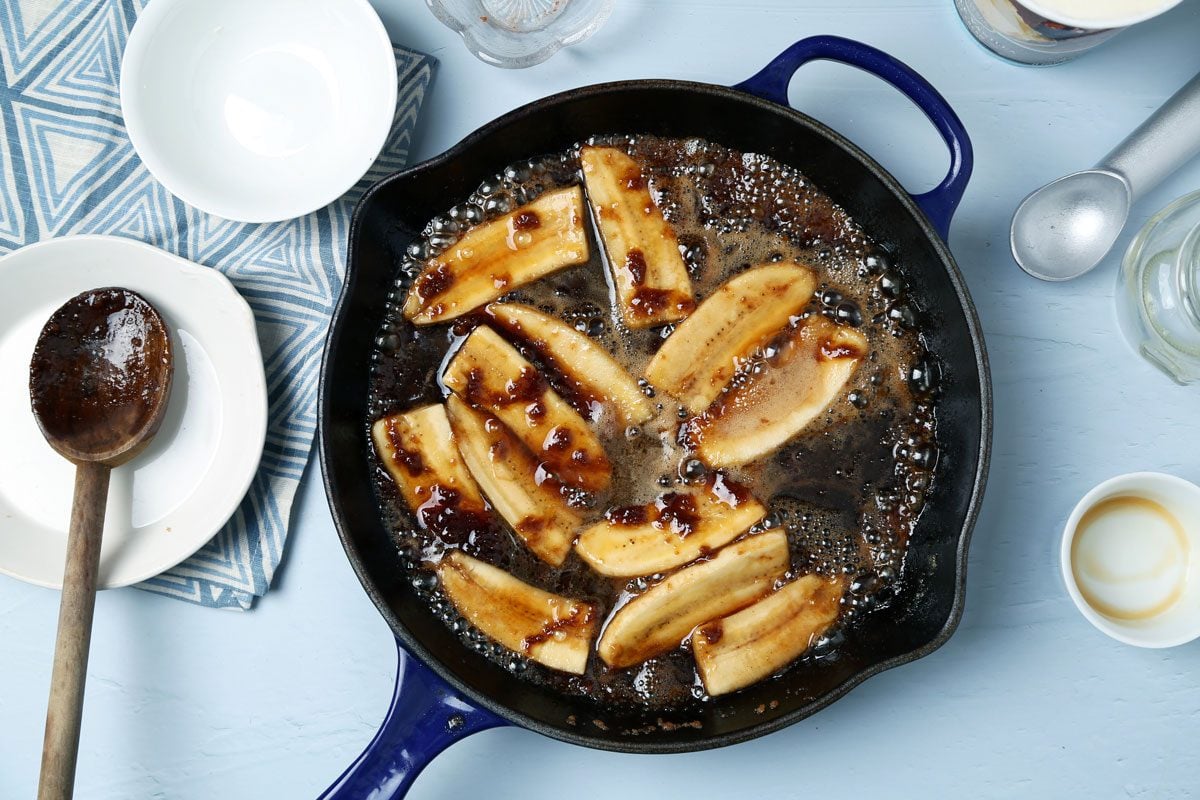 Process of making Taste of Home's bananas foster laid out on a light blue surface with a blue linen.