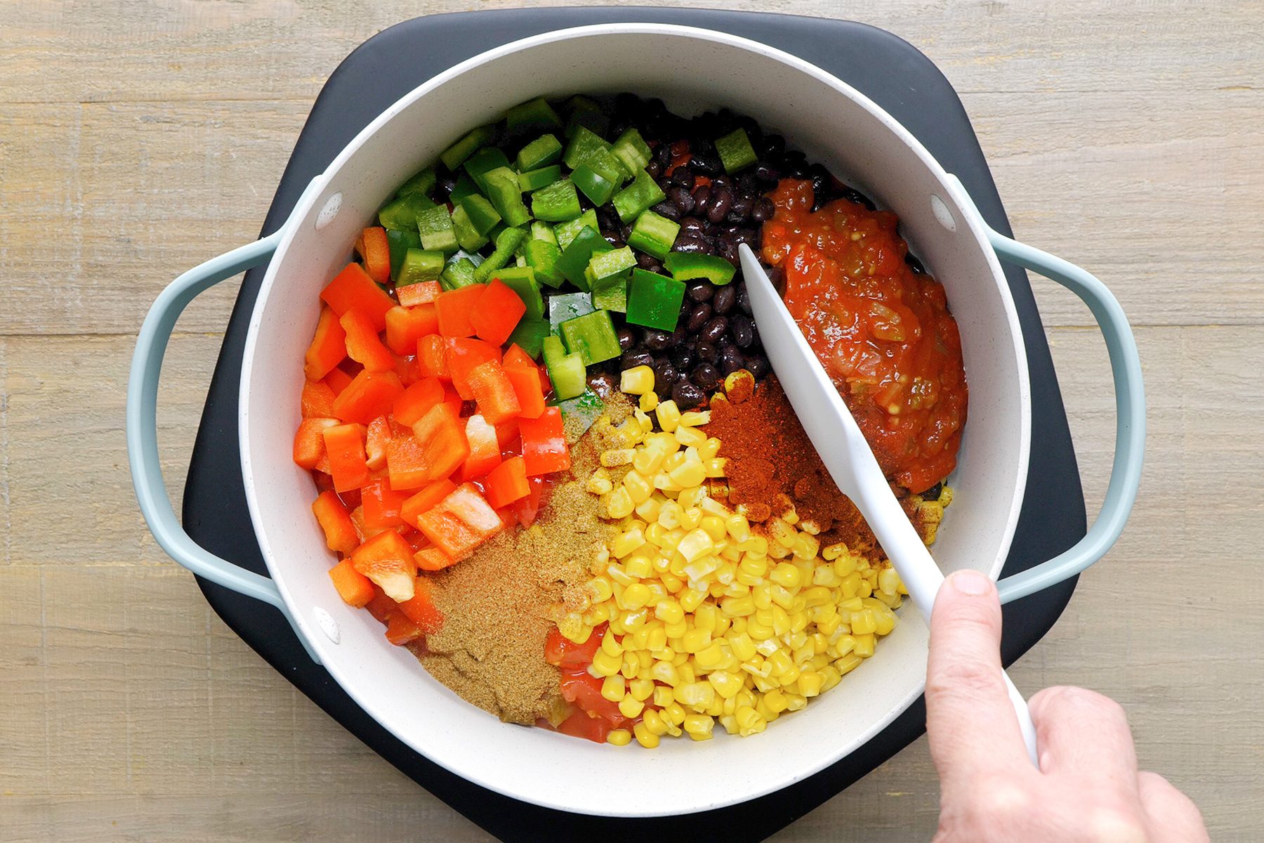 Mixing vegetables and spices to gather before boiling in a pan to prepare Vegetarian Chili