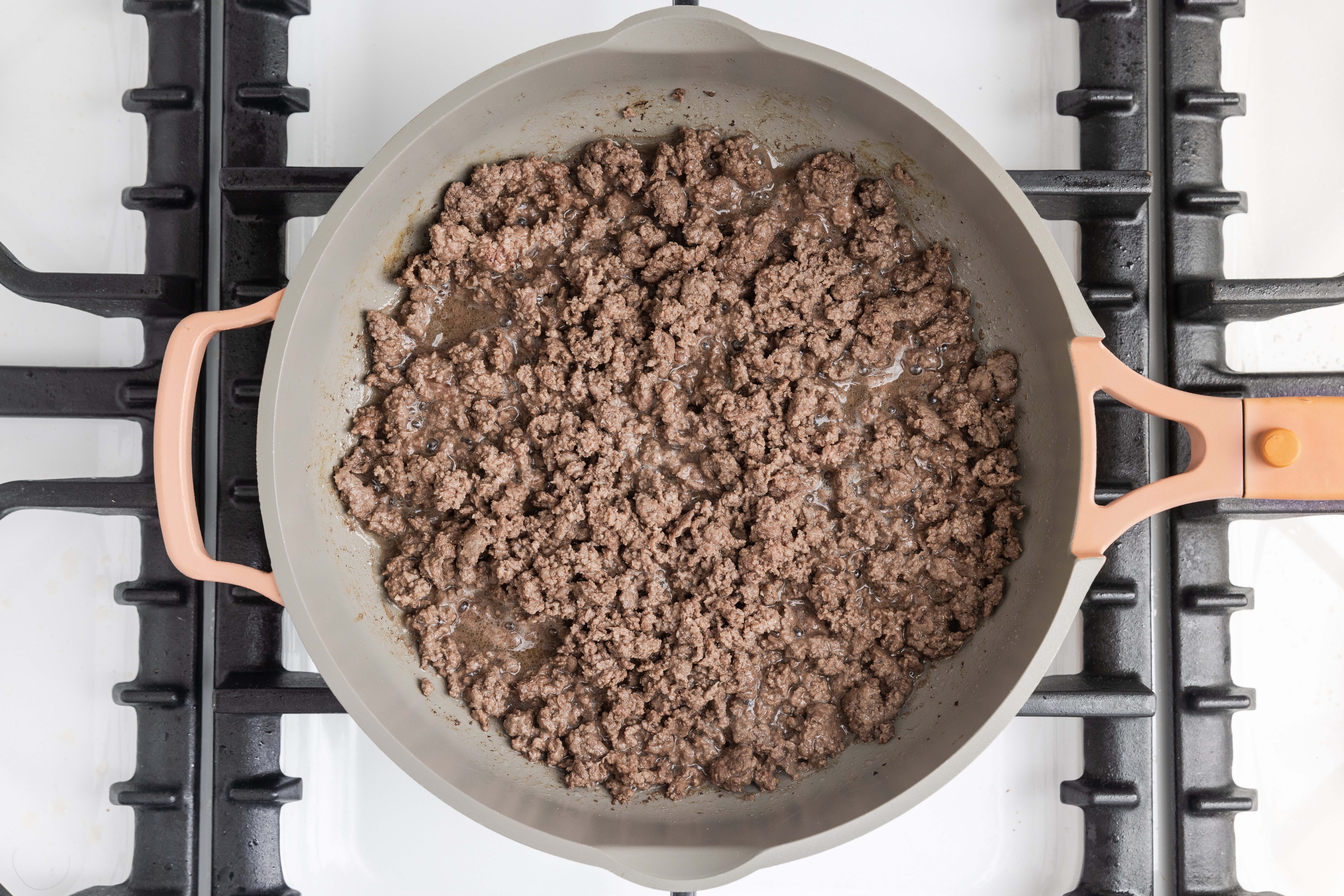 Ground beef cooking in skillet.