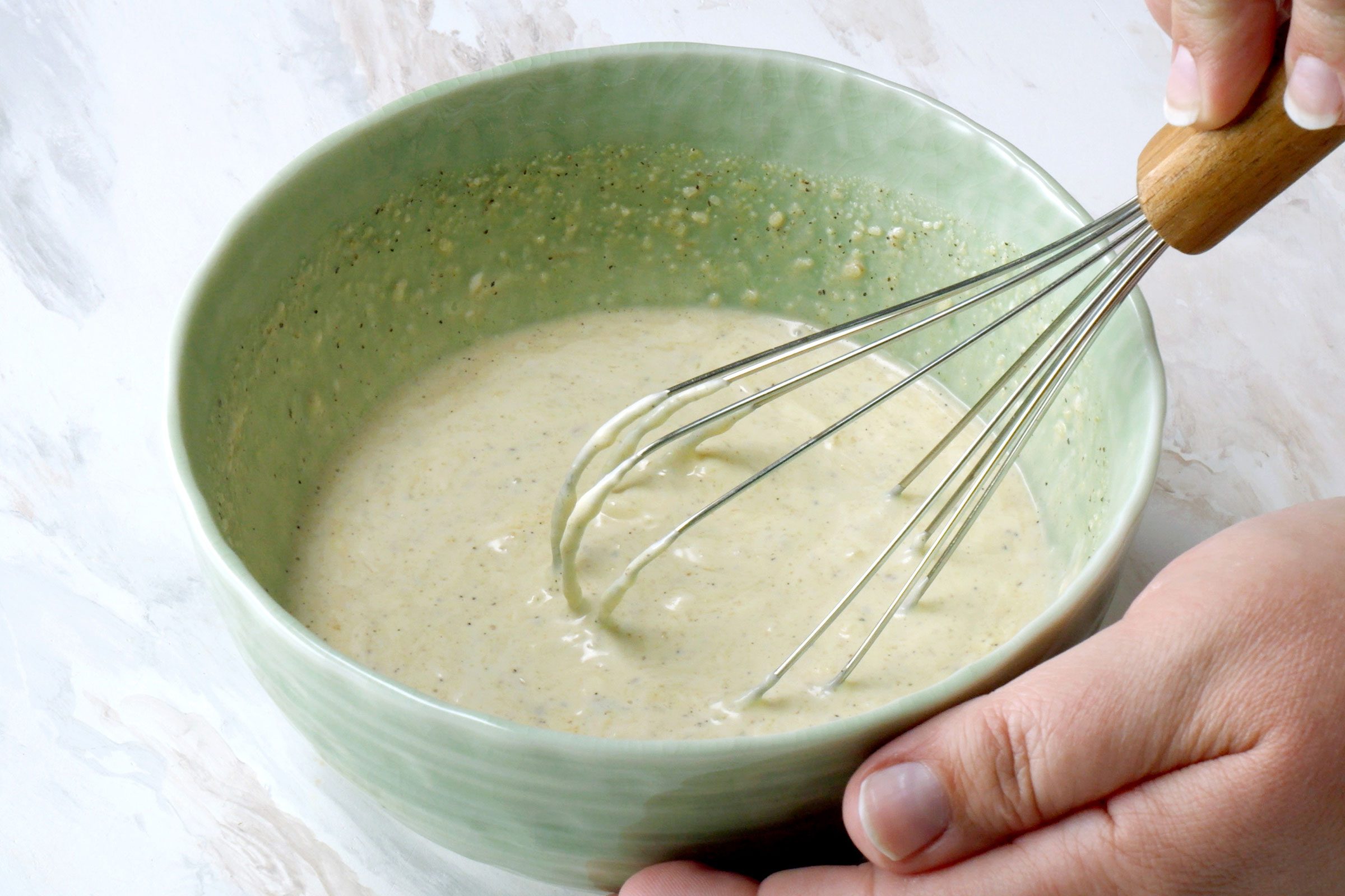 Caesar Dressing ingredients whisked together in a small bowl