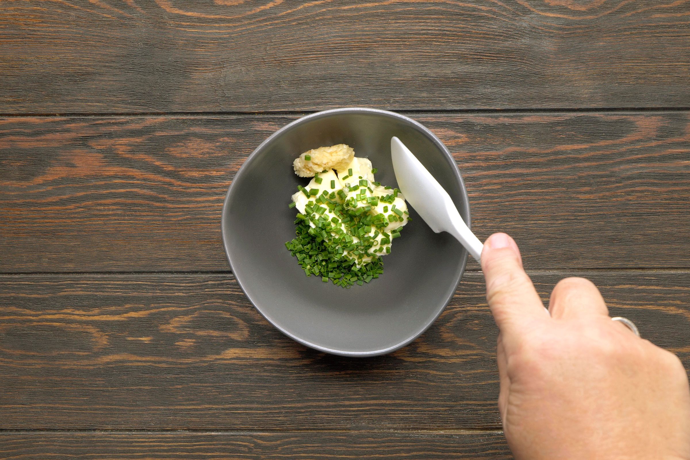 Butter, chives and garlic in a small bowl mixed with butter knife