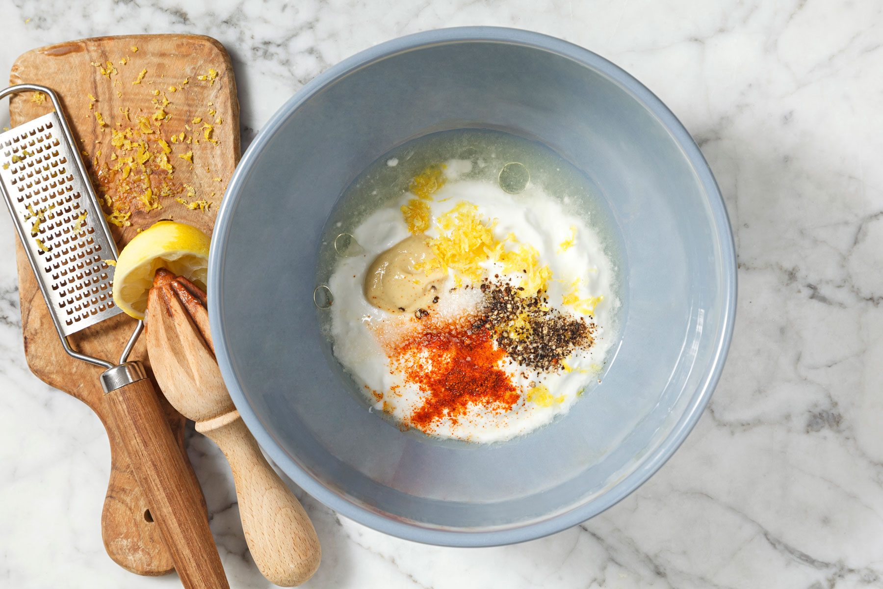 yogurt, lemon juice, olive oil, Dijon mustard, lemon zest, salt, pepper and cayenne pepper in a bowl