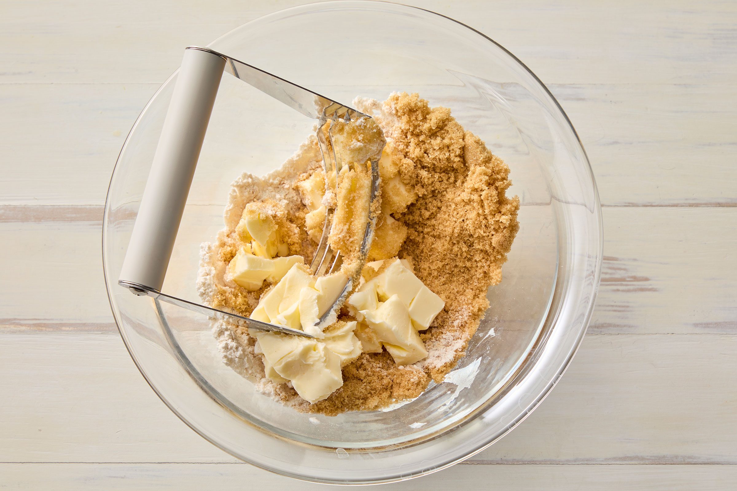 Mixing flour, sugar and butter in a glass bowl 