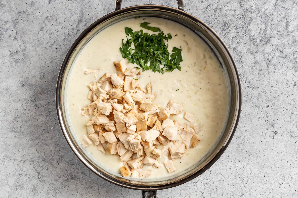 Taste of Home Creamed Chicken Over Biscuits photo of the chicken and parsley added to the cream sauce.