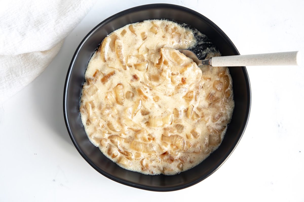 Overhead shot for Taste of Home Creamed Onions being served in a small black bowl.