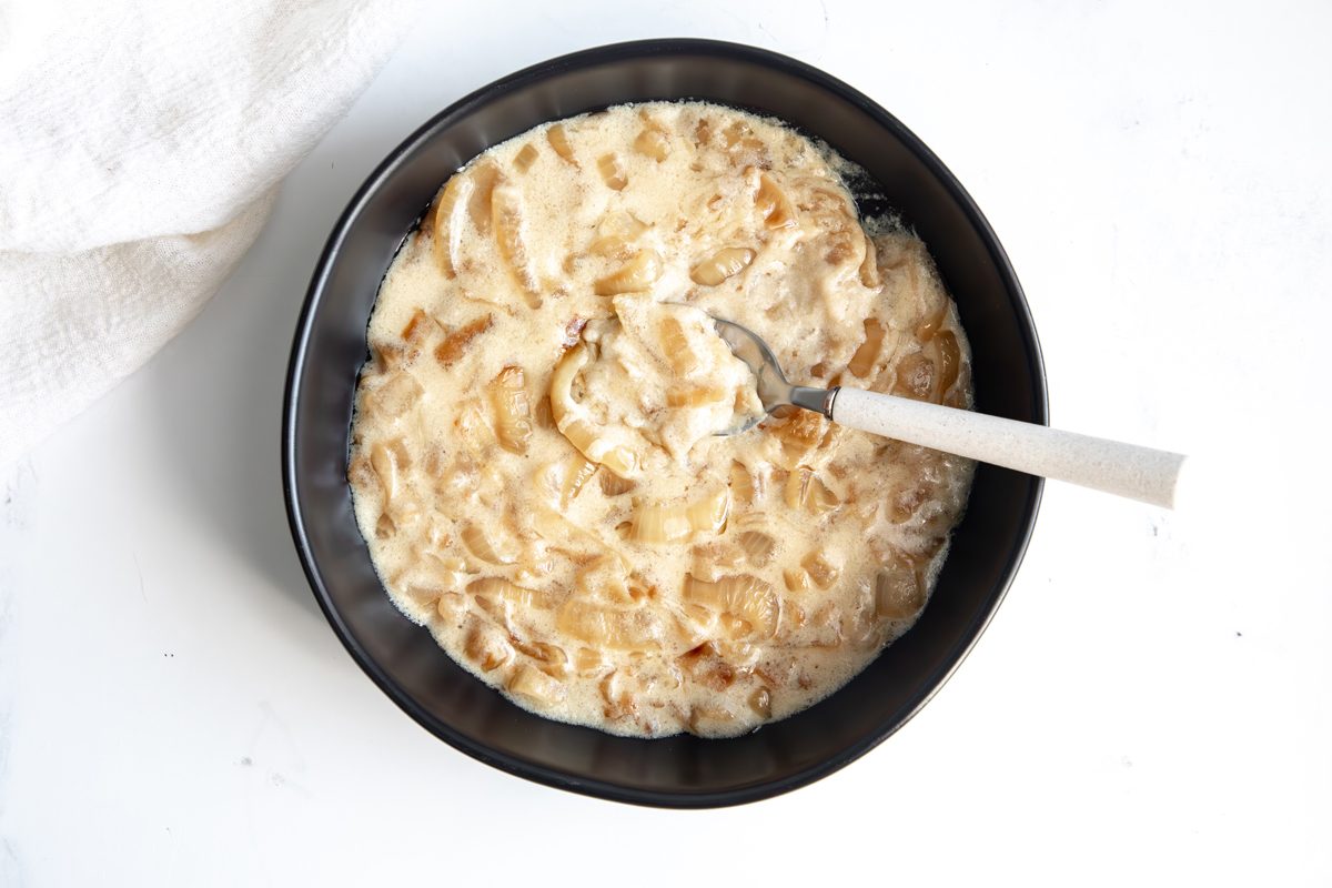 Beauty shot for Taste of Home Creamed Onions being served in a small black bowl.