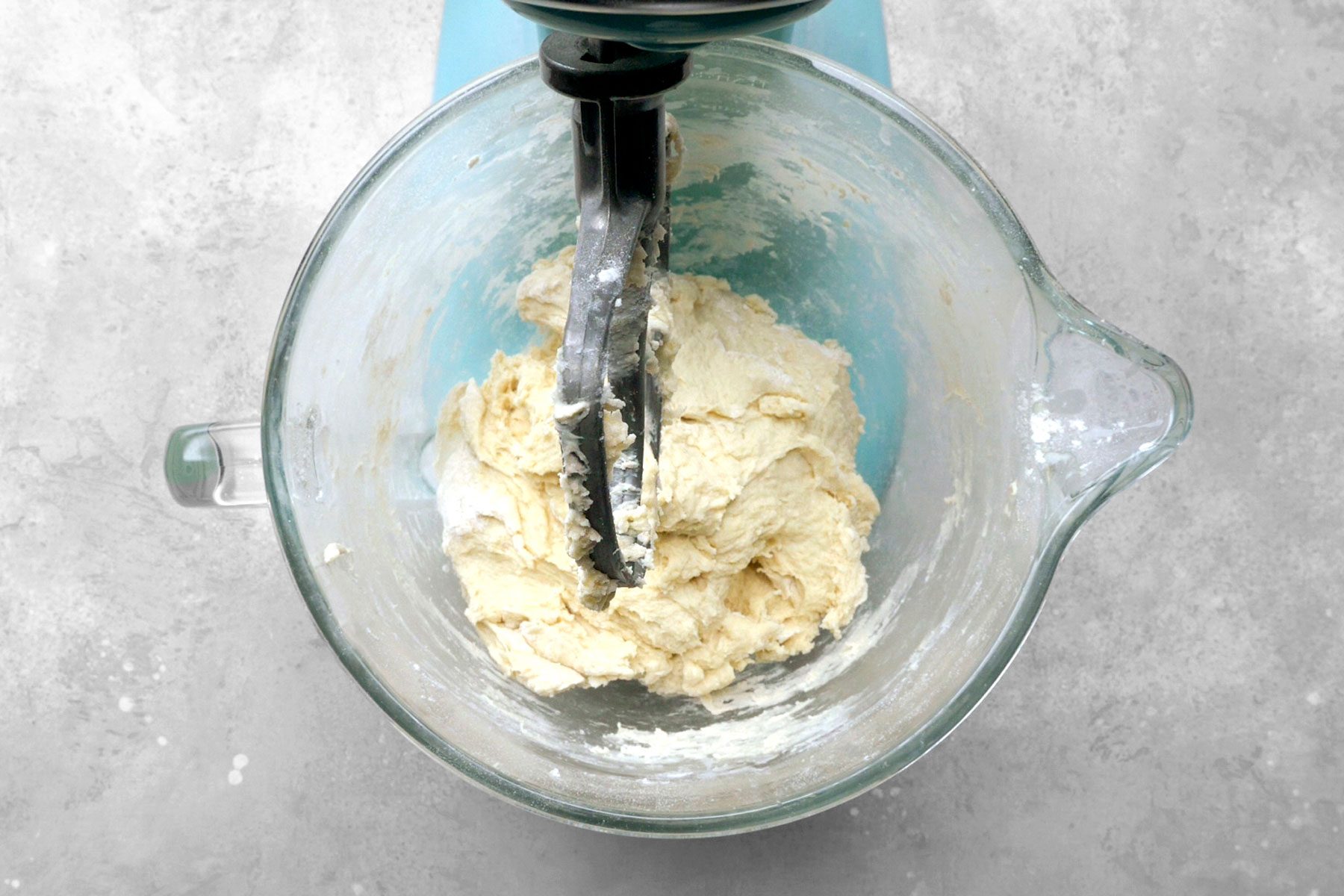 Dough being mixed in a large bowl.