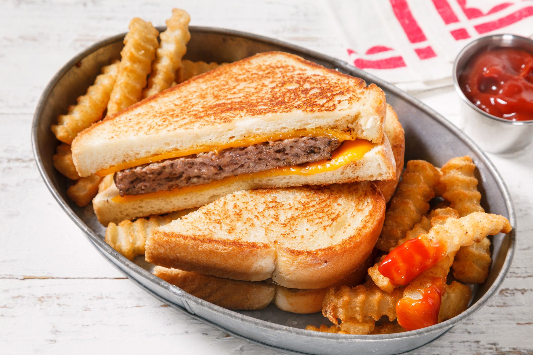 3/4th shot of Grilled Cheeseburgers served with mustard and tomato sauce.