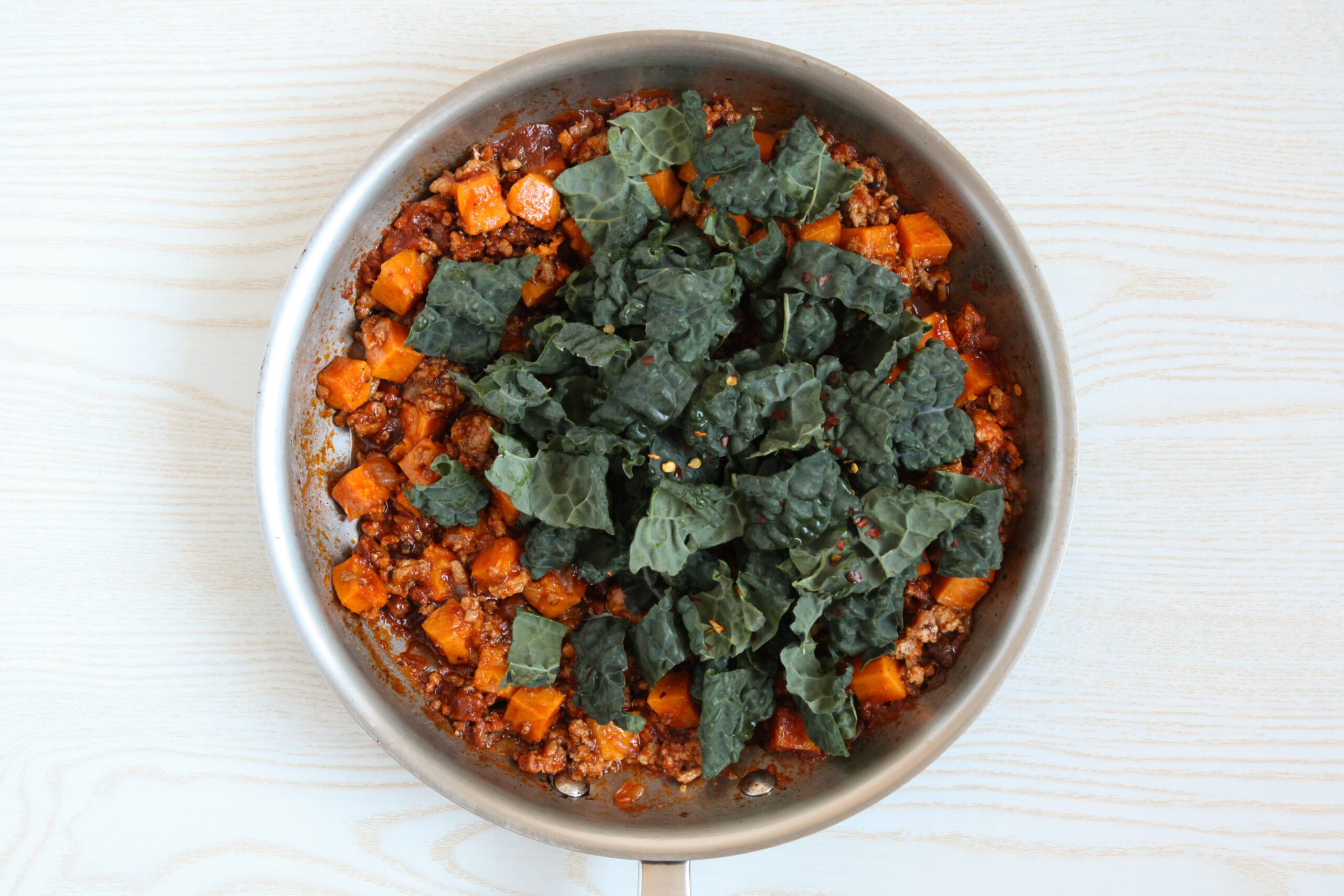 Adding kale to the skillet